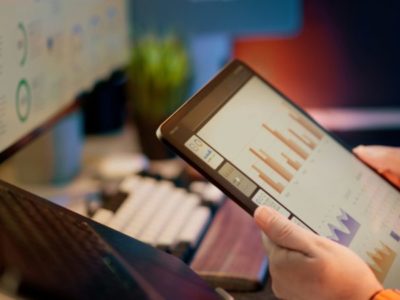 Person reviewing business analytics and sales data on a tablet dashboard.